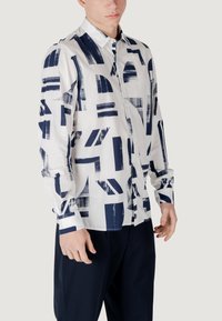 Witte button-up shirt met een abstract marineblauw penseelstrekenpatroon, lange mouwen en een standaard kraag. Gladde stof met een relaxte fit.