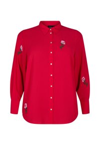 Sarkana garā piedurkņu krekls ar pogu priekšpusi, norādītu apkakli un ziedu izšuvumu uz piedurknēm. Izgatavots no gludas auduma ar brīvu piegriezumu.