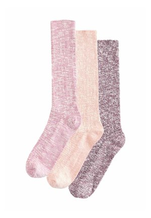 Tre par stickade ankelsockor i färgerna rosa, ljus persika och vinröd med en melerad textur, lagt överlappande på en vit bakgrund.