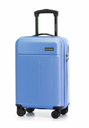 Valigia rigida di colore azzurro chiaro con texture a righe verticali, manico estensibile nero e quattro ruote nere. Logo del marchio visibile.