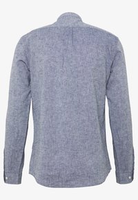 Koszula z długim rękawem wykonana z jasnoniebieskiej, teksturowanej tkaniny. Posiada standardowy kołnierz, mankiety zapinane na guziki oraz zaokrąglony dół. Widok od tyłu ukazuje detale szwów na ramionach.