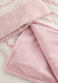 Weiches, flauschiges Decke in zartem Rosa mit einer strukturierten, flauschigen Oberseite und einer glatten, plüschigen Unterseite. Die Kanten sind ordentlich gesteppt.