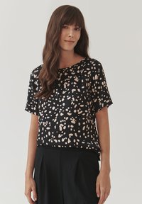 Blusa nera a maniche corte con un motivo maculato in beige chiaro. Tessuto morbido con vestibilità comoda e scollatura rotonda.