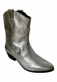 Botín de tobillo de cuero plateado con un acabado texturizado, puntera afilada y un bajo tacón negro. Presenta acentos de costura de estilo western.