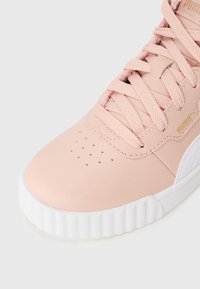 Baskets en cuir rose avec surface texturée, semelle en caoutchouc blanc, lacets roses et perforations discrètes. Dotées d'un détail logo en or.