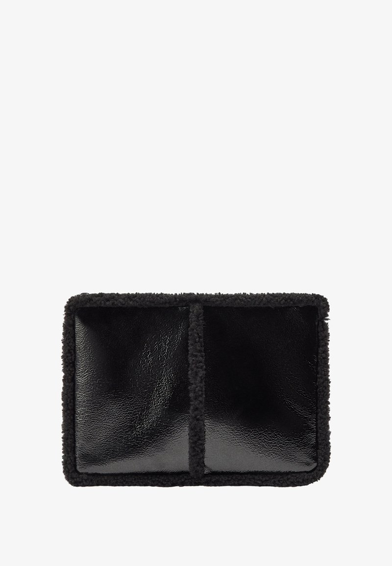 Czarna skórzana torba z miękkim, teksturowanym obszyciem z owczej wełny, w prostokątnym kształcie, z dwiema przegrodami oddzielonymi szwem środkowym.