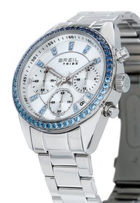 Montre en acier inoxydable argenté avec un cadran blanc, des pierres précieuses bleues sur la lunette et trois sous-cadrans. Comprend un bracelet à maillons et une fenêtre de date.