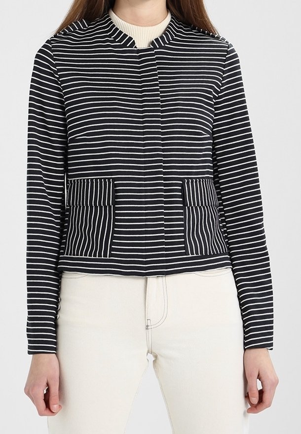 Marynarka w paski w kolorach granatowym i białym, z okrągłym dekoltem, dwoma przednimi kieszeniami oraz krótkim fasonem i długimi rękawami. Miękka, elastyczna tkanina.