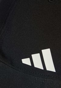 Gorra negra de tela con una textura suave; presenta un destacado logo de tres rayas blancas en la parte frontal. Detalles de costura visibles.