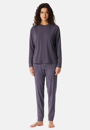 Lila långärmad tröja i kombination med mönstrade pyjamasbyxor som har ett vågigt mönster, tillverkade av mjukt och bekvämt tyg.