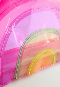 Transparent taske med lagdelt regnbue-design i pink, gul og grøn, med syede kanter i matchende farver. Glat overflade.