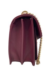 Borsa a mano in pelle borgogna con tre scomparti e tracolla in catena dorata, vista di lato su sfondo bianco.