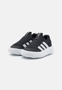 Svart strikkede sneakers med hvite striper, teksturert overdel, myk såle og håndtak på hælen for enkel påføring.