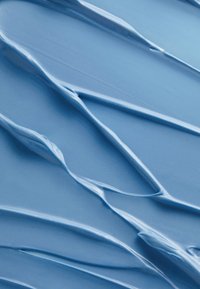 Hellblaue cremige Substanz mit glatter, fließender Textur und erhabenen, wellenförmigen Mustern. Wirkt glänzend mit einem dezenten Glanz.