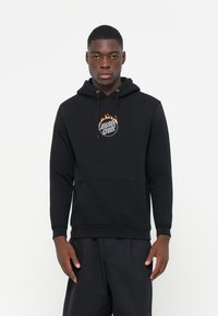 Zwarte hoodie met een voorzak, verstelbare trekkoordcapuchon en een "Santa Cruz" logo in vlammen. Glad materiaal en normale pasvorm.