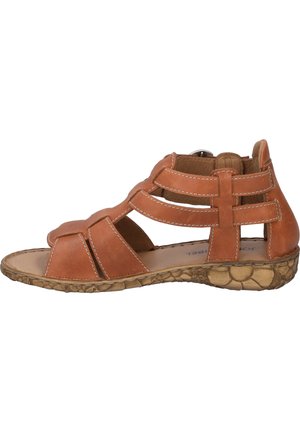 Tan leather sandal with multiple straps, open sides, and a textured, natural rubber sole. Features stitched accents and a low heel.