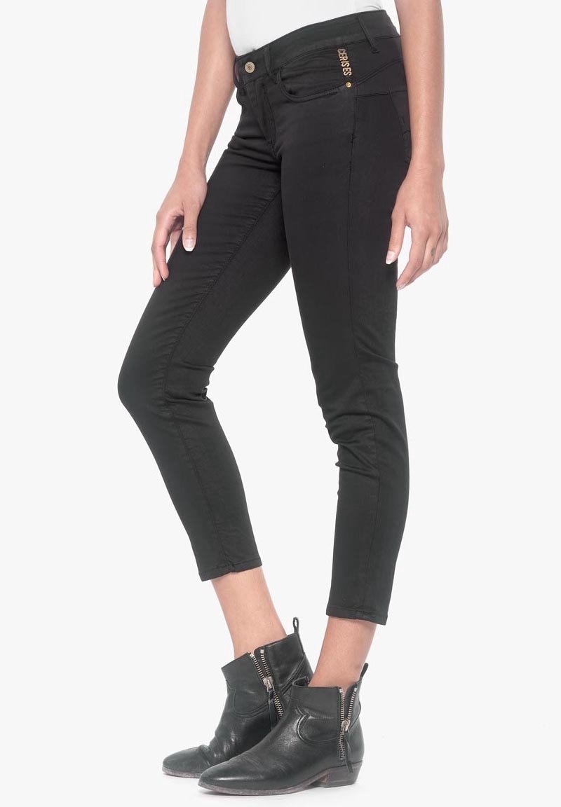 Černé denimové džíny s úzkým střihem, zkrácenou délkou a zipovým detailem na kotníku. Disponují zlatým knoflíkem a švy jako ozdobnými prvky.