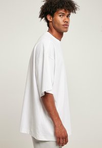 Løs pasform hvid bomulds t-shirt med korte ærmer, rund halsudskæring og en afslappet form. Minimalistisk design og glat tekstur.