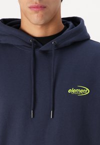 Navy blue hooded sweatshirt made of cotton-blend material, featuring a front logo in bright green, with drawstring details.