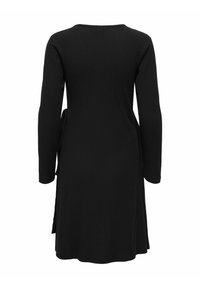 Robe noire à manches longues en maille côtelée, avec un ourlet mi-long et une ceinture nouée sur le côté, vue de dos.