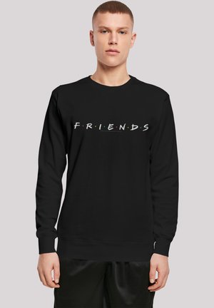 Svart hettegenser med ordet "FRIENDS" i hvitt og fargerike prikker, laget av bomullsblanding, med rund hals og ribbestrikkede ermer.