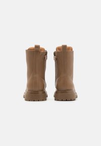 Brune lær ankle boots med en glat overflade, der har en sidelukning, en trækflap og robuste gummisåler for godt greb.