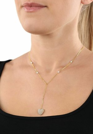 Collana d'oro a forma di Y con un pendente a cuore decorato con pietre trasparenti scintillanti e piccoli accenti rotondi lungo la catena.