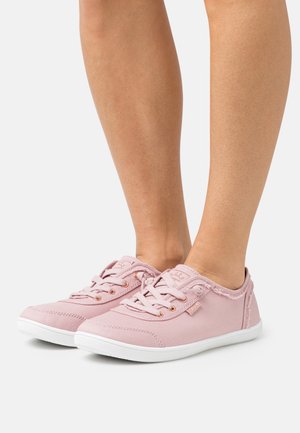 Baskets en toile de couleur rose clair avec un design à lacets, semelle en caoutchouc blanche et œillets en or rose. Présente des détails effilochés le long des bords.