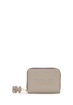 Cartera rectangular beige con texto "TOUS" en relieve, cuero texturizado y un tirador de cremallera a juego en forma de oso de peluche.