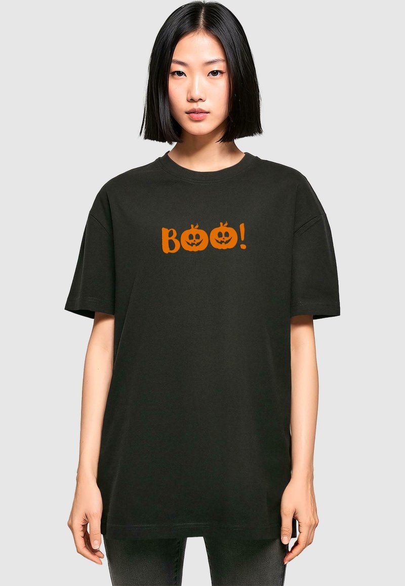 Tricou negru din bumbac cu croială oversized, având o grafică portocalie cu două dovleci de Halloween și cuvântul "Boo!" impriminat deasupra acestora.