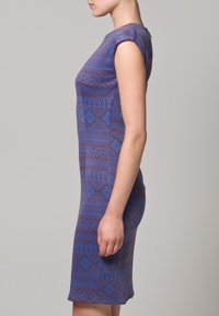 Robe sans manches violette avec un motif géométrique agrémenté de touches bleues et rouges. Silhouette ajustée, longueur genou, tissu texturé.