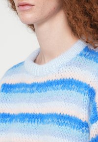 Ελαφρύ πλεκτό πουλόβερ με οριζόντιες ρίγες σε απαλές αποχρώσεις του μπλε και του ανοιχτού ροζ, με ριμπ λαιμόκοψη και υφασμένη υφή.