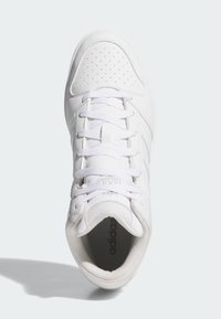 Biele atletické tenisky s perforovanými detailmi, plochými šnúrkami a štruktúrovanou podrážkou. Značka viditeľná v oblasti päty a jazyka.