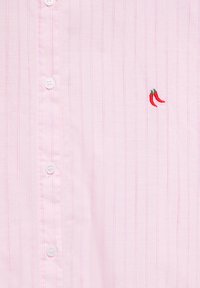 Chemise rose clair à boutons avec fines rayures verticales rose foncé et petits piments rouges brodés sur le côté droit.