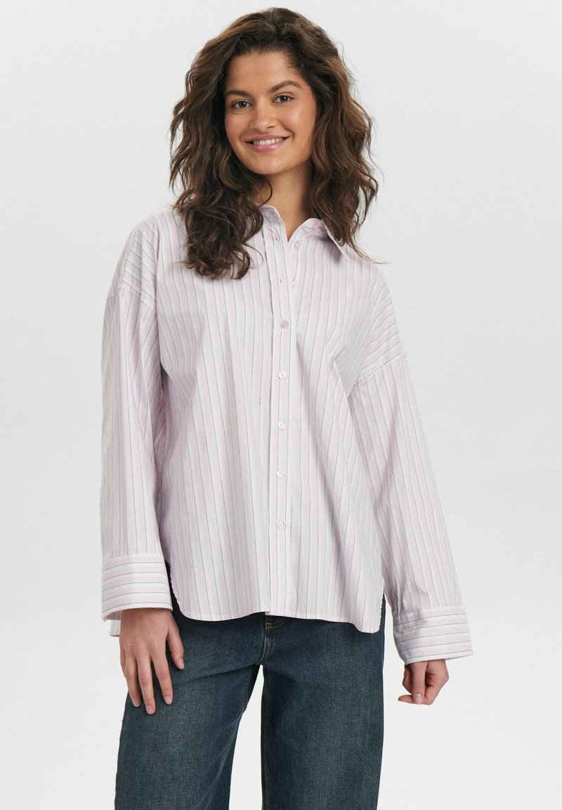 Light pink and white striped button-up shirt with a collar, oversized fit, and long sleeves. Smooth fabric with visible buttons.