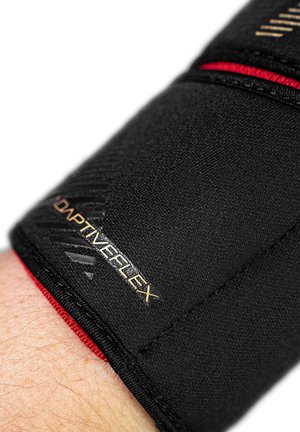 Schwarze adaptive Unterstützungsmanschette aus strukturiertem Stoff, mit roten Akzenten und goldener "ADAPTIVEFLEX"-Markierung, entworfen für Komfort und Flexibilität.