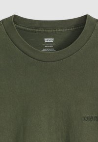 Olijfgroene katoenen T-shirt met een geribde ronde hals en een gestikte Levi's-logo in een donkerder groen op de borst. Relaxte pasvorm, zachte textuur.