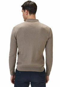 Tan ribbad långärmad tröja med polo-krage och åtsittande manschetter; har ett strukturerat vertikalt mönster och en jämn tygfinish.