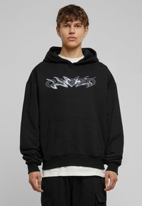 Sort sweatshirt med hætte, der har et blankt, stiliseret logo på tværs af brystet. Textureret stof og ribbede manchetter og kant.