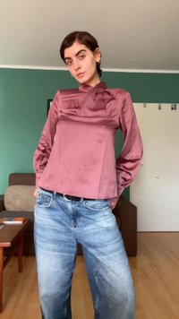 Rožinė satino ilgarankovė palaidinė su kvadratiniu iškirpimu ir kaspinėlio detale, derinama su šviesiai mėlynomis nusidėvėjusiomis plačiomis kelnėmis.