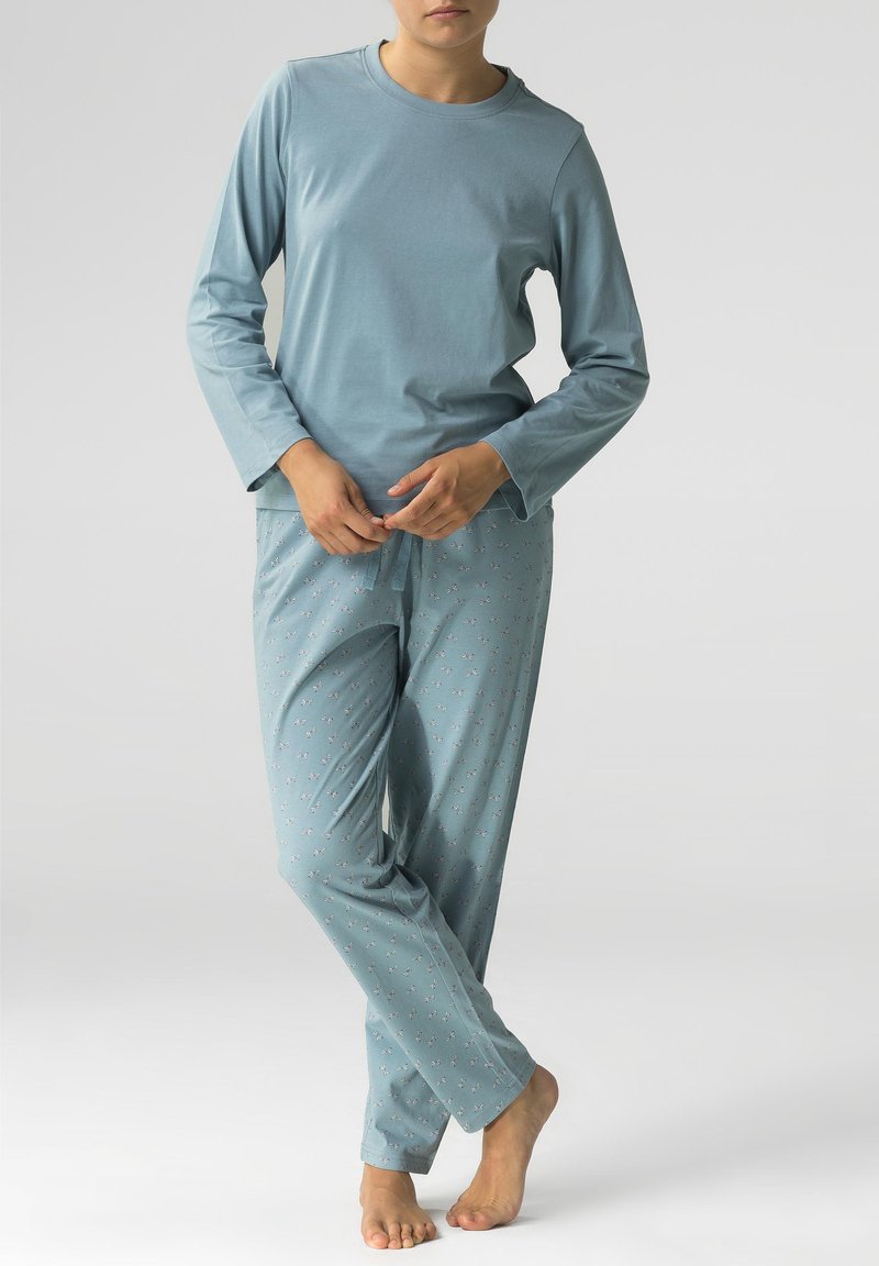 Jasnoniebieska bluzka z długim rękawem połączona z piżamowymi spodniami na troczki z małym florystycznym wzorem. Miękka, lekka tkanina, luźny krój.