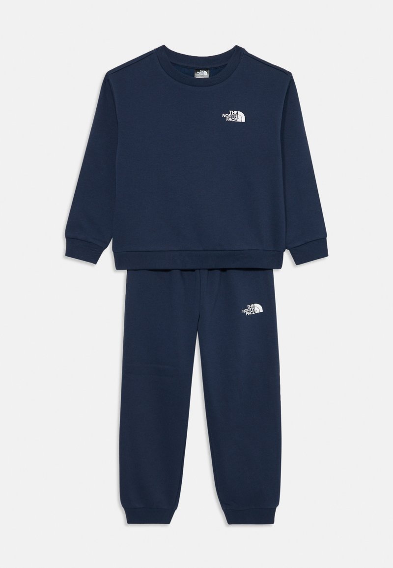 Navy blue sweatshirt and pants set, featuring ribbed cuffs and a logo in white on the chest and left pants leg. Soft textile material.