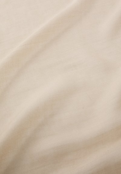Lys beige stoff med en glatt tekstur, som har subtile folder og et fint vevmønster, som skaper et mykt og dempet utseende.