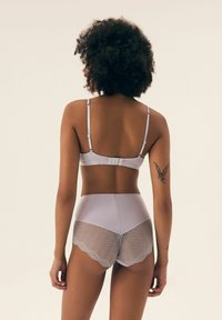 Jasnoszary biustonosz z regulowanymi ramiączkami i zapięciem na haczyk, w połączeniu z majtkami o wysokim stanie z falbaniastym wykończeniem i wzorem w warkocz.