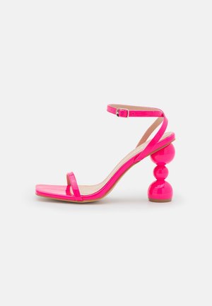 Højhælet sandal i skrigende pink med ankelrem og skulpturel hæl med tre stabler af kugler, åben tå og tynd frontrem.