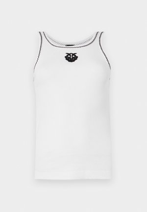 Hvit ermeløs ribbestrikket tanktop med svart sikksakk-søm på utringning og armåpninger, med en liten svart brodert emblem på brystet.