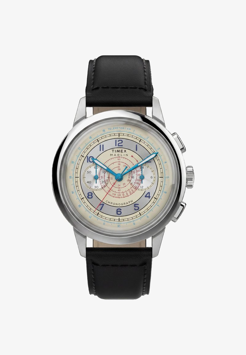 Στρογγυλό χρονογράφος ρολόι Timex Marlin με ασημί κάσα, μπεζ καντράν, μπλε δείκτες, μαύρο δερμάτινο λουράκι και δύο υποκαντράν που δείχνουν δευτερόλεπτα και λεπτά.