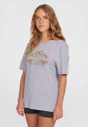 Ljuslila t-shirt i mjuk bomull, med ett blommönster i pastellfärger centrerat på framsidan. Kort ärm, avslappnad passform.