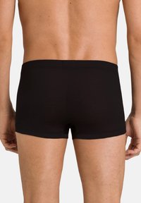 Zwarte boxershorts van gladde stof, met een eenvoudig ontwerp, een elastische tailleband, een aansluitende snit en minimale stikseldetails.
