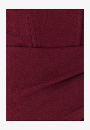 Burgundi tekstuuriga kangas siledat pinnaga, millel on voldid ja sobiv disain, rõhutades puhtaid jooni ja diskreetset läiget.